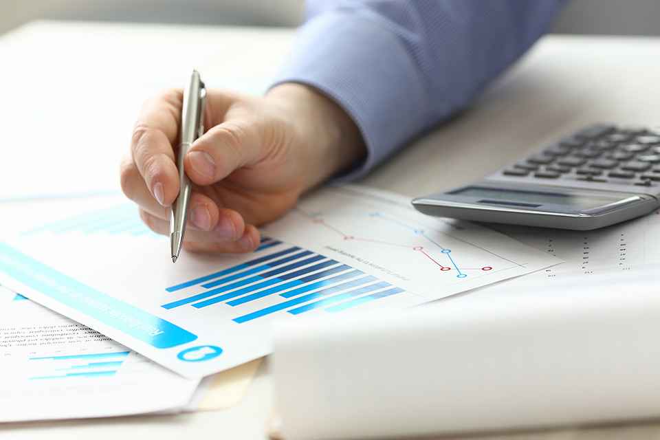 Foto: Person zeigt mit Stift auf Akten